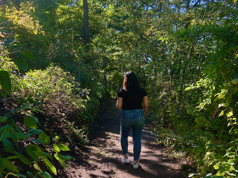 A students walks in the UC Botanical Garden.