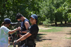 Steven Zeng (right) smiling on set as a cinematographer.