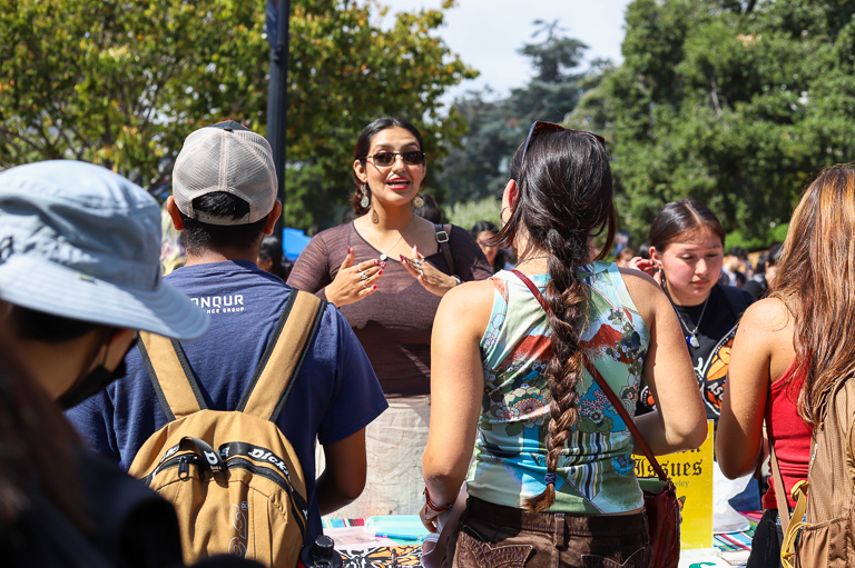 Jasmine Lozano speaks to two prospective club members while tablig or Brown Issues at Calapalooza.