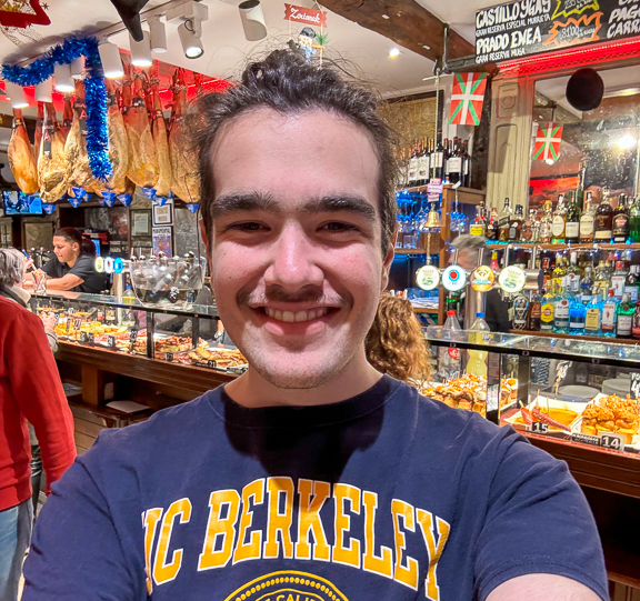 A selfie of Vincent smiling in Spain, sporting a UC Berkeley shirt.