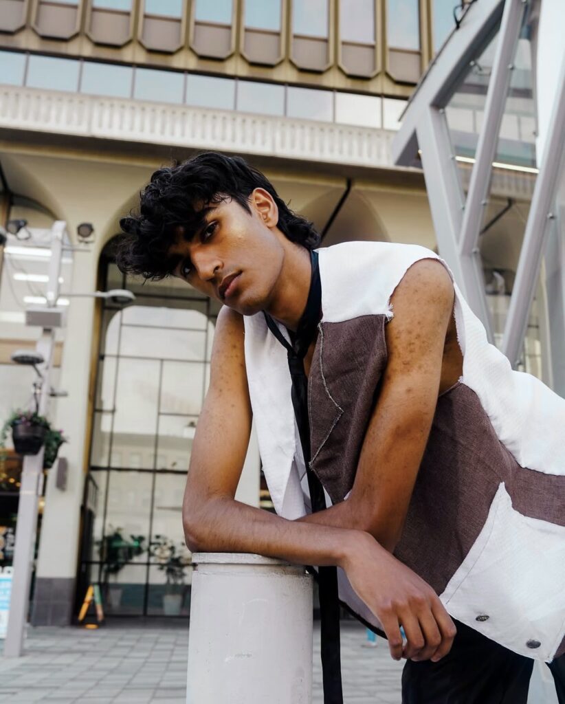 A student model for Fashion and Student Trends (FAST) poses in a brown and white vest.