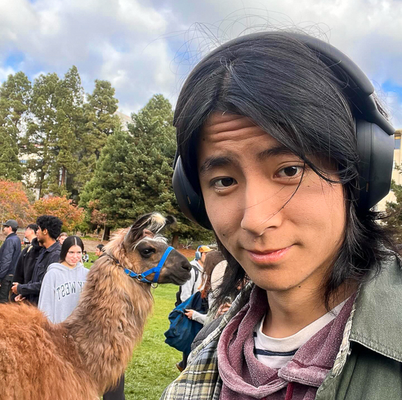 Daniel poses with a llama on Memorial Glade during RRR Week of fall 2023.